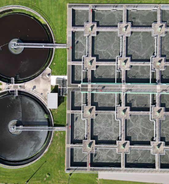 Home Aerial view of a modern wastewater treatment plant with filtration tanks.